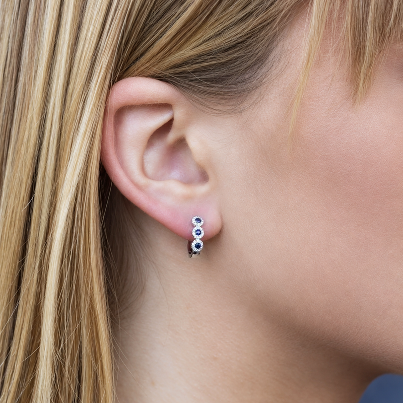 14K Gold Sapphire Halo Huggie Earrings Worn on Ear